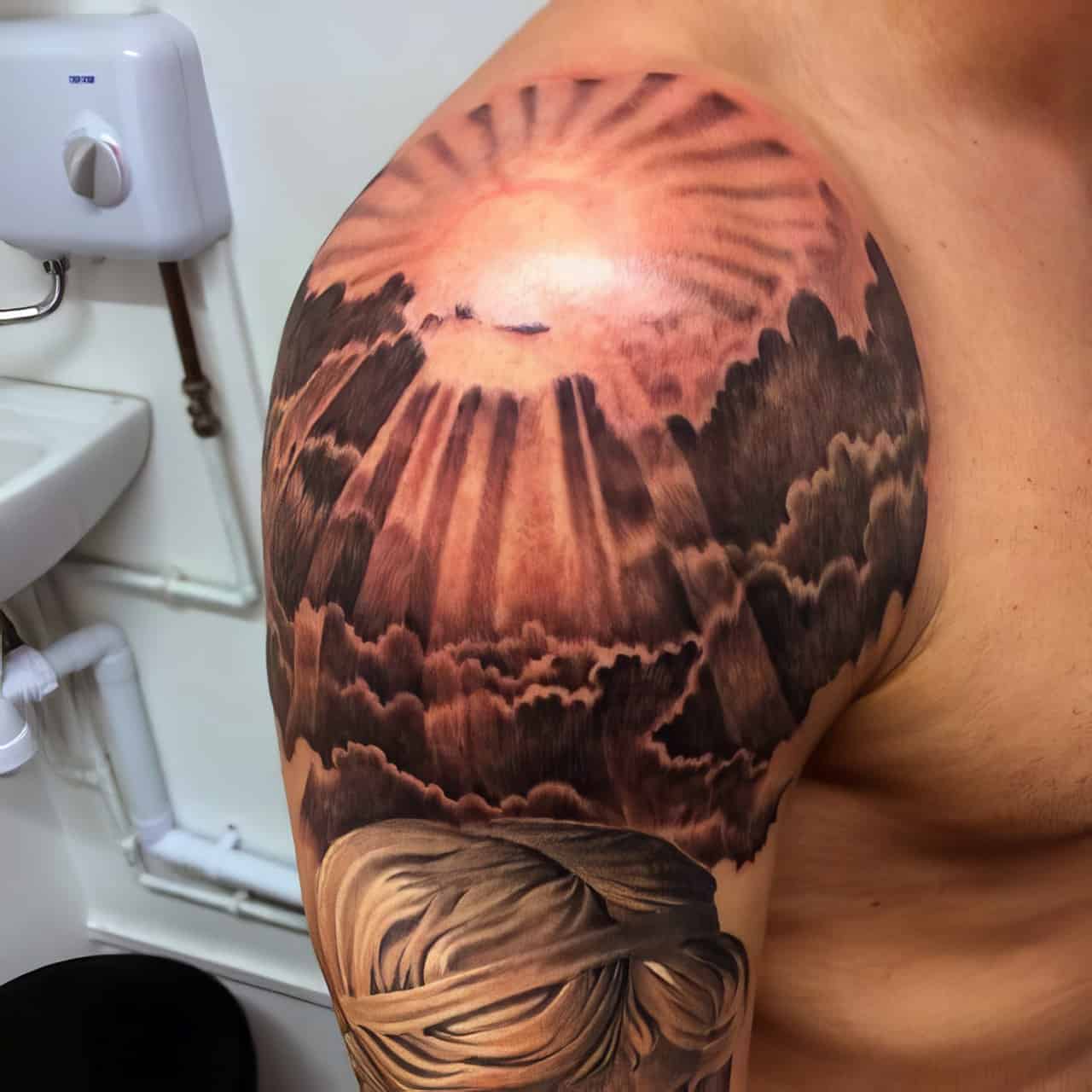 sun rays on shoulder tattoo